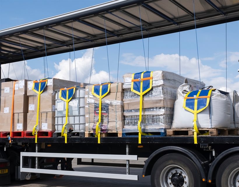 Six bundles of cargo secured to a trailer with cargo securing straps 
