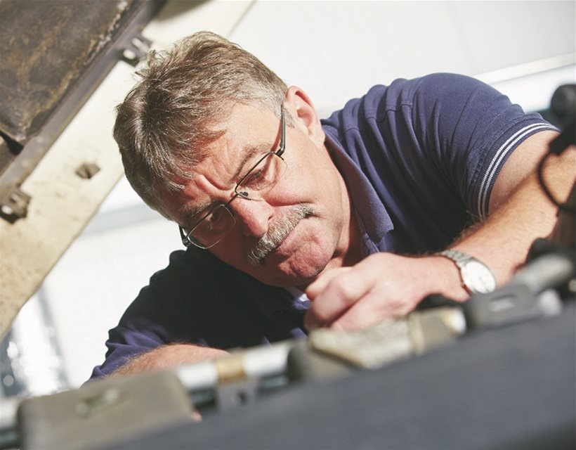 A person in a navy polo working on a mechanical application