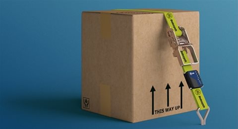 A carboard box strapped down by cargo securing straps 