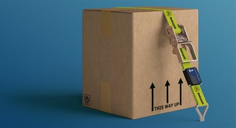 A cardboard box being strapped down with a cargo securing strap